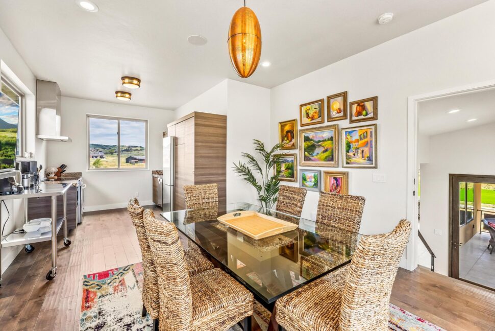 A dining room table with chairs and a painting on the wall.